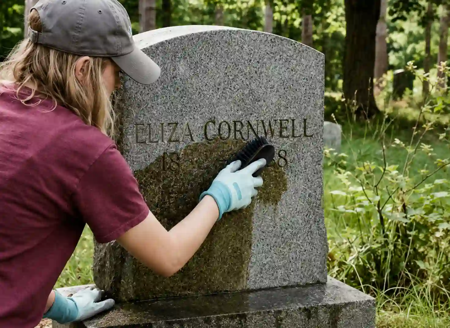Low-pressure spray cleaning a weathered marble headstone